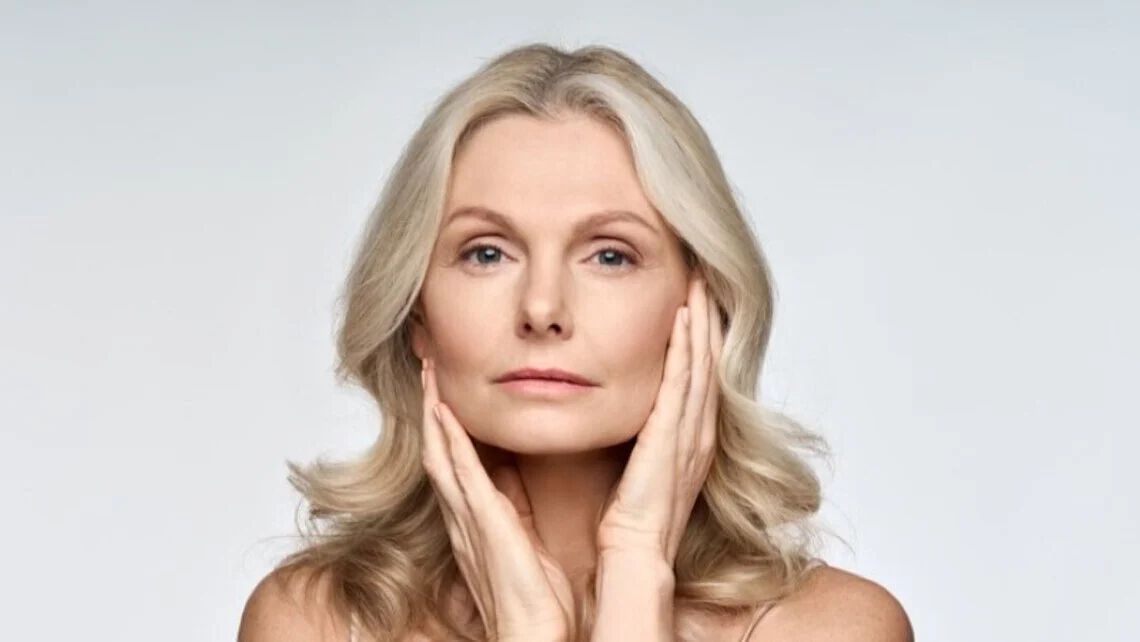 Frau ab 50 beruhrt ihr Gesicht
