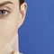 Gesichtshaut, die Maske abzieht, vor blauem Hintergrund.