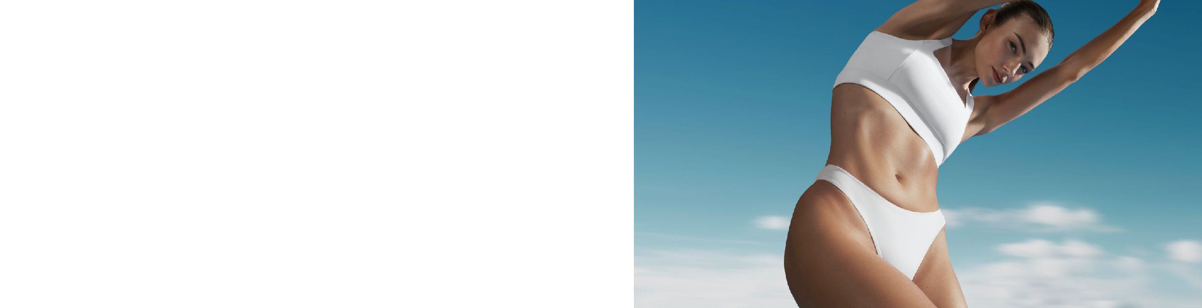 Person in Bademode am Strand vor blauem Himmel und wolkenlosem Hintergrund.