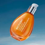 Frasco y tarros Biotherm Aquasource+ de vidrio naranja sobre fondo naranja brillante, con tapas plateadas y gel hidratante visible.