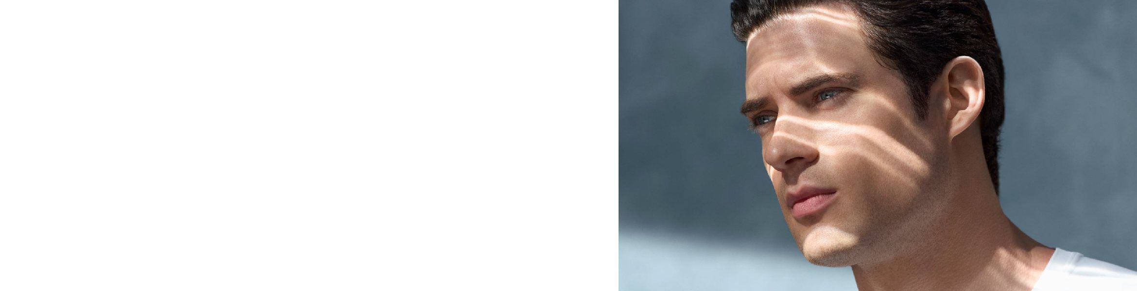 Rechtes Gesicht eines Mannes, schauend; Hintergrund ist unscharfer, blauer Himmel.