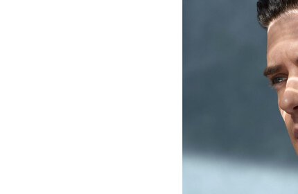 Rechtes Gesicht eines Mannes, schauend; Hintergrund ist unscharfer, blauer Himmel.