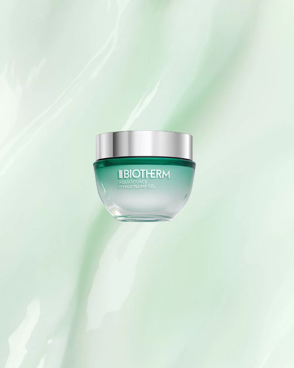 Ein gruner Creme-Tiegel mit silbernem Deckel schwebt vor einem hellgrunen Hintergrund. Text: "BIOTHERM AQUASOURCE HYALU PLUMP GEL".