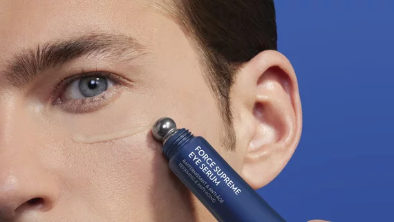 man applying eye serum around his eye