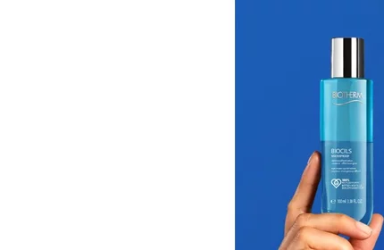 Eine Hand halt eine blaue Biotherm-Flasche vor blauem Hintergrund, Text: "BIOSOURCE HYDRATING & TONIFYING TONER" und weitere Details.