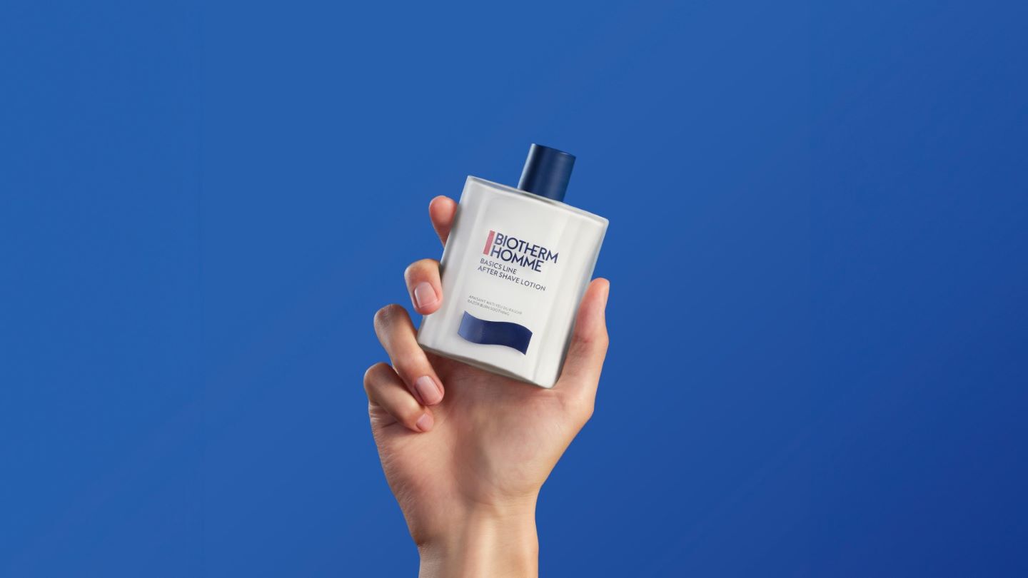 Emulsion apres-rasage dans une main sur fond bleu