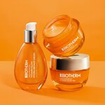 Biotherm Aquasource+ Hautpflegeprodukte in orangefarbenen Glasflakons und -tiegeln vor leuchtend orangem Hintergrund, mit silbernen Deckeln und sichtbarem Gel.