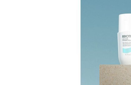 Flasche steht auf einem Betonblock vor blauem Himmel. Text auf der Flasche: "BIOTIS Sense Sunscreen."