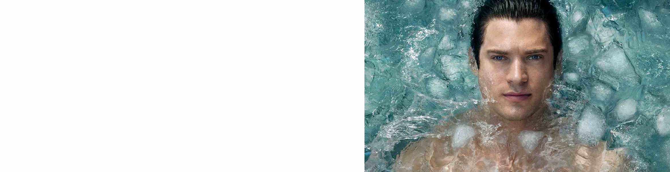 Turkisblaue Wellen brechen an einem sandigen Strand, umgeben von schaumendem Wasser.