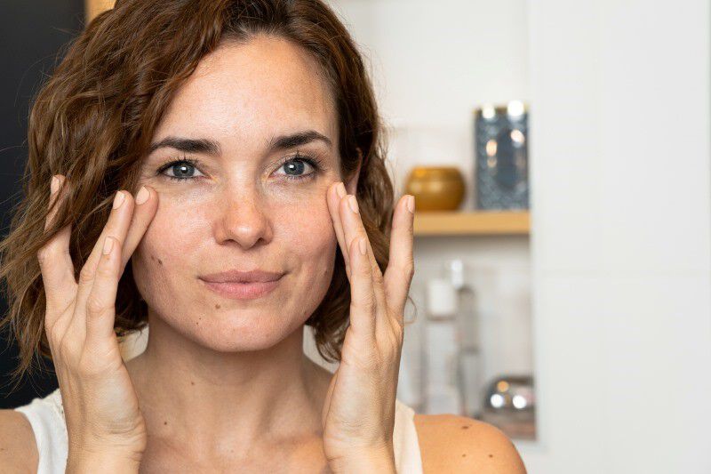 Femme qui touche ses taches de soleil