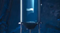 Blaue Flasche auf Metallgestell vor dunkelblauem Hintergrund.