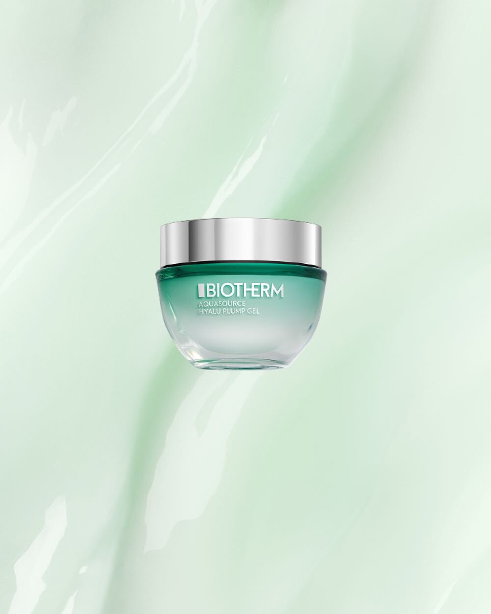 Ein grunliches Kosmetiktiegel mit silbernem Deckel schwebt vor einem pastellgrunen Hintergrund. Text: "BIOTHERM AQUASOURCE HYALU PLUMP GEL".