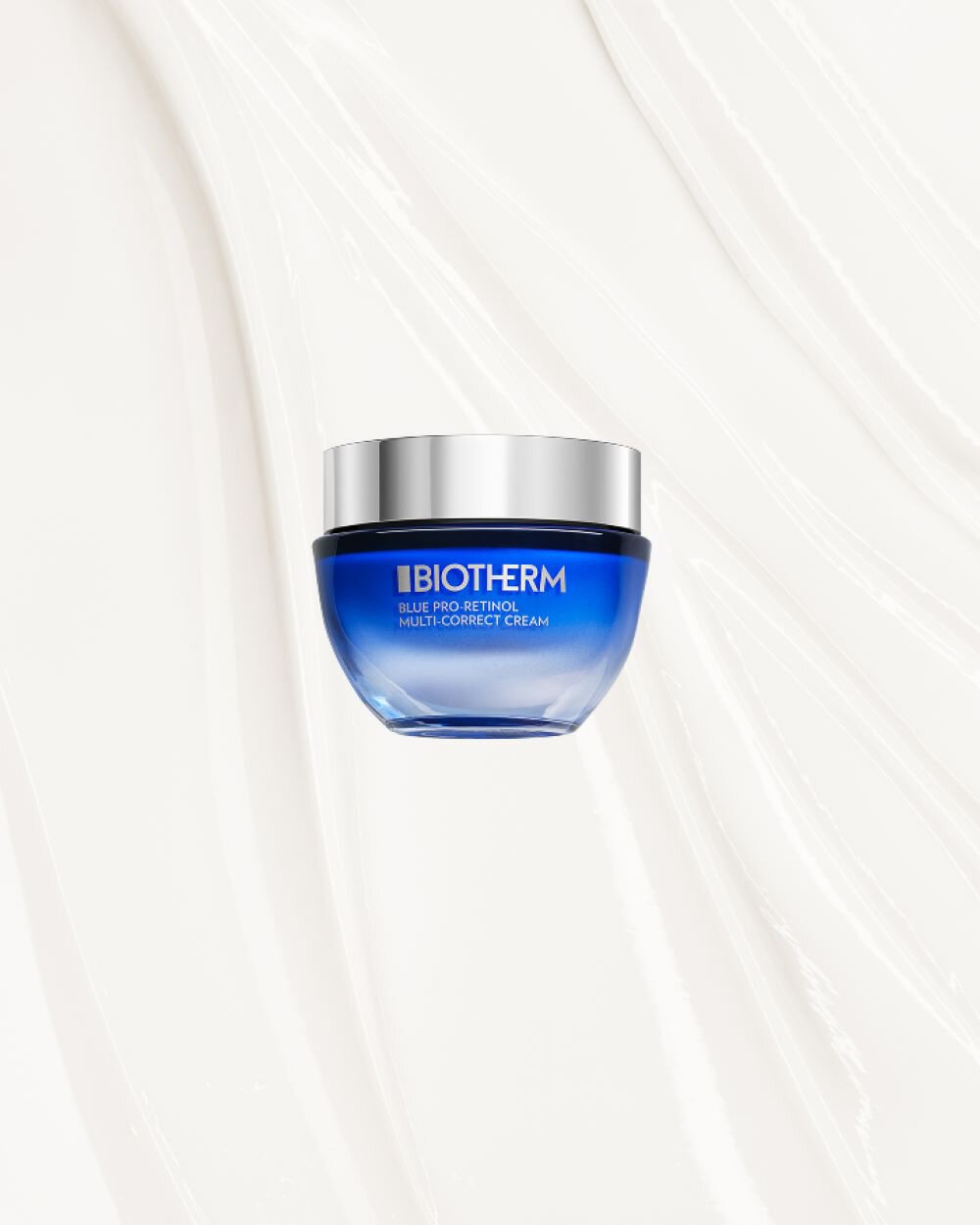 Blauer Cremetiegel mit silbernem Deckel schwebt vor weißem Hintergrund. Text: "BIOTHERM BLUE PRO-RETINOL MULTI-CORRECT CREAM".