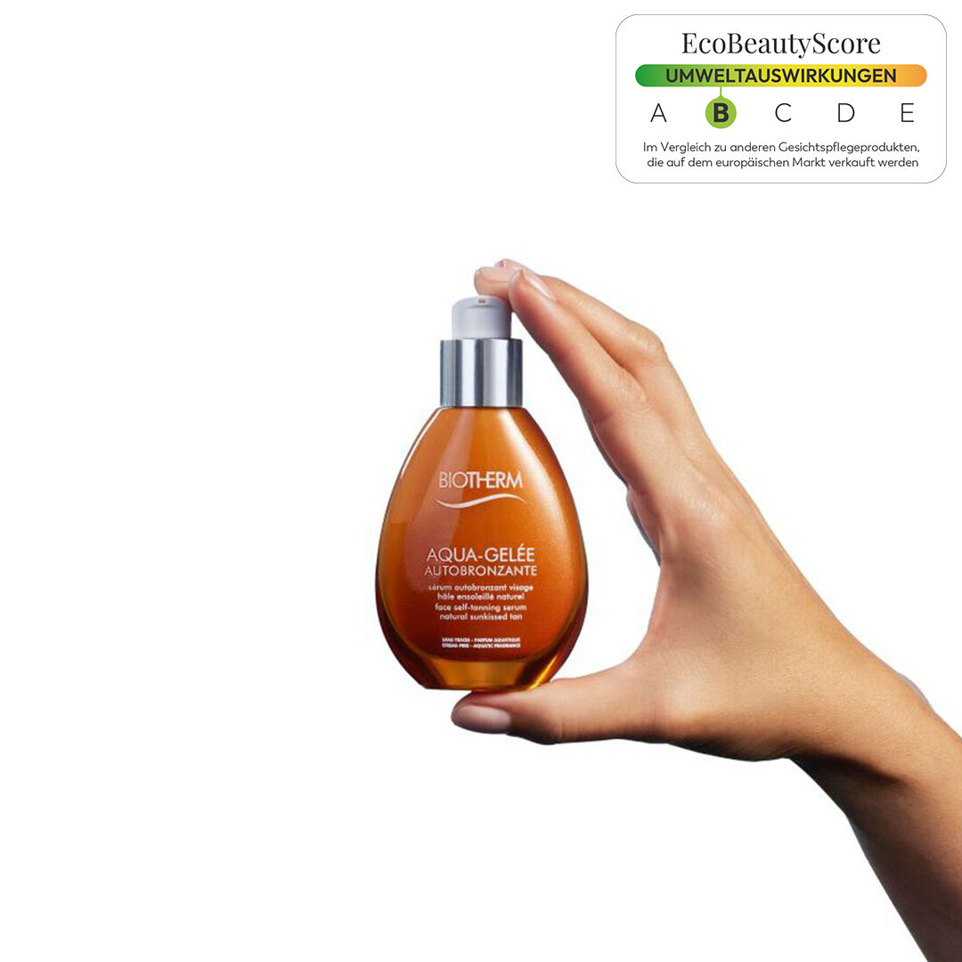 Eine Hand halt eine parfumformige Flasche vor einem weißen Hintergrund.