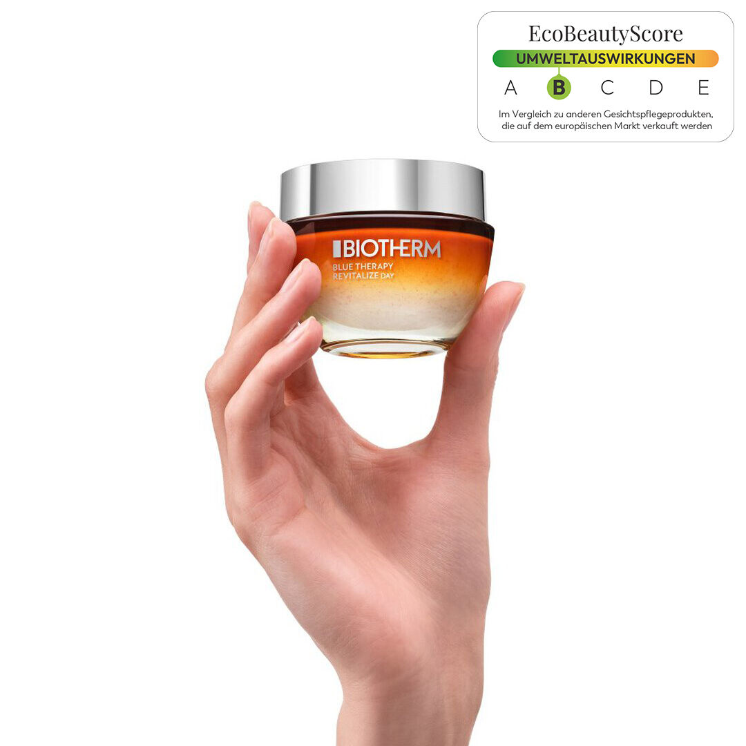 Eine Hand halt ein Glas mit einer silbernen Kappe; weißer Hintergrund.