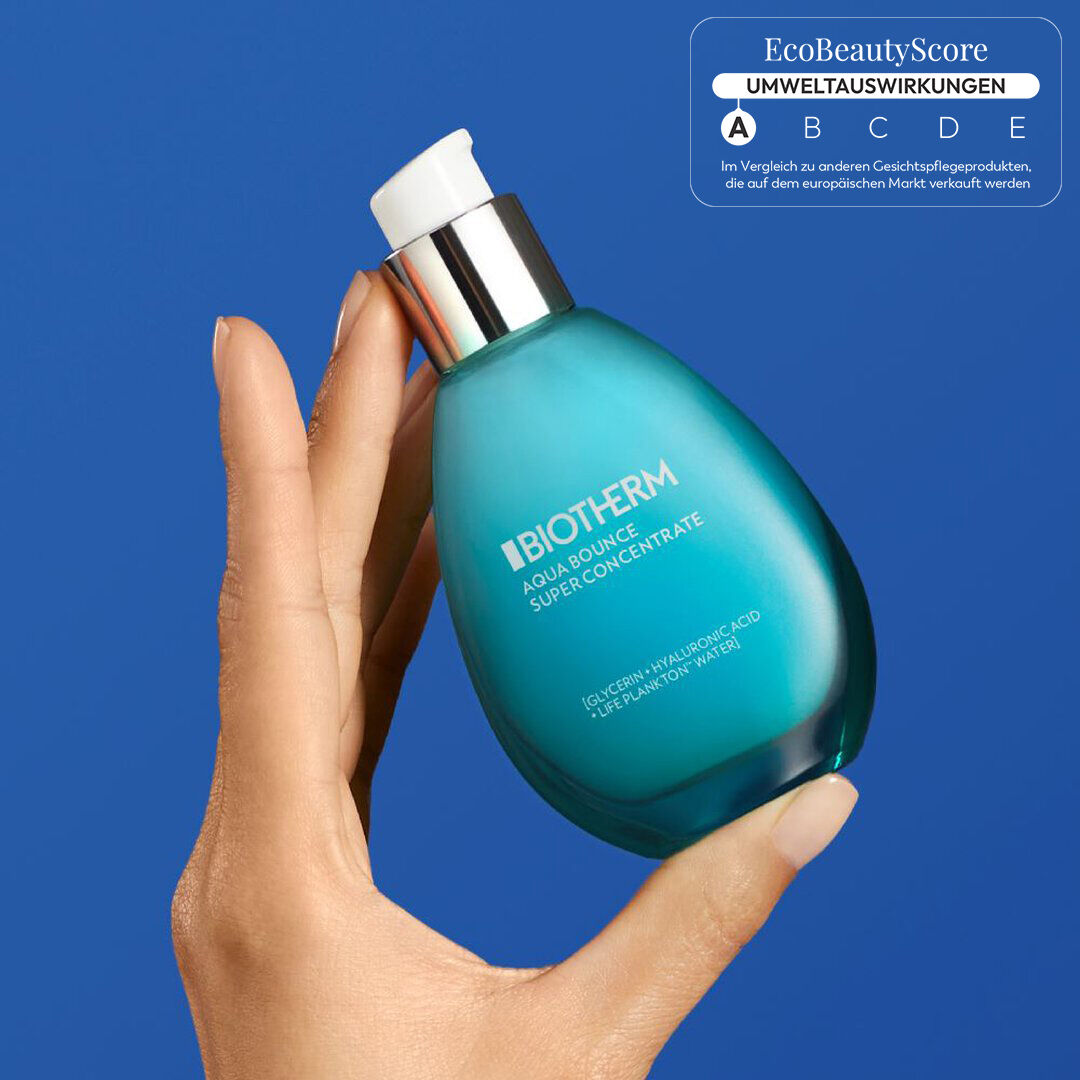 Hand halt turkisfarbenes Flaschchen mit Aufschrift „AQUACITY Perfume“ vor blauem Hintergrund.