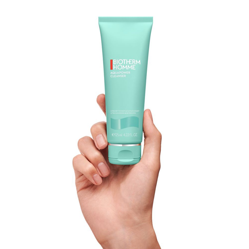 Hand halt grune Tube mit dem Aufdruck „St. Ives Blackhead Clearing Green Tea Scrub“ vor weißem Hintergrund.