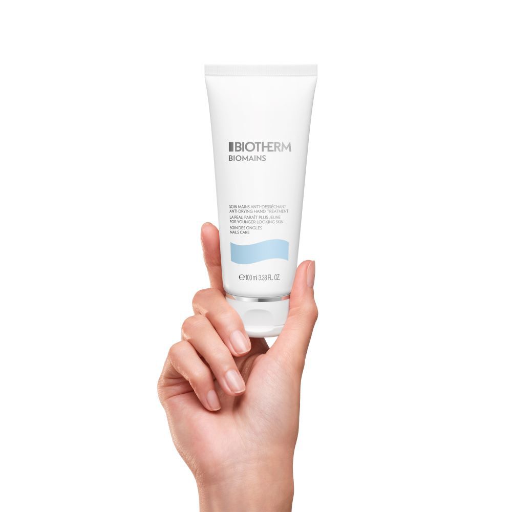 Hand halt Creme-Tube vor weißem Hintergrund.