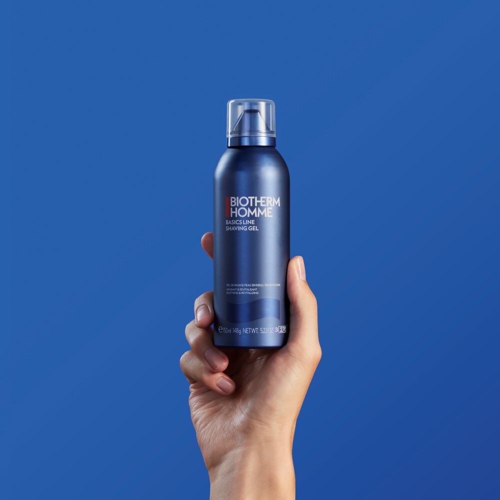 Hand halt blaue Flasche vor blauem Hintergrund; Text: „Water in aluminium. Infinitely recyclable“.
