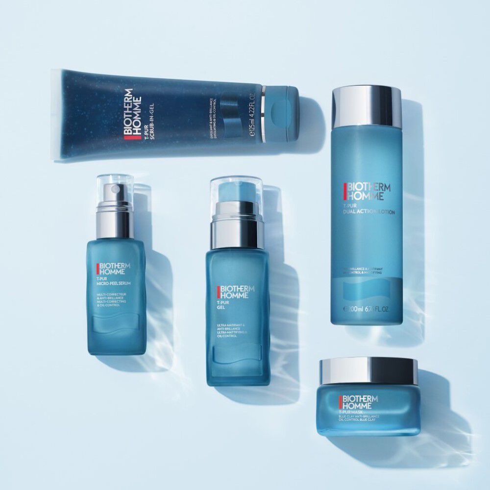 Funf blaue Kosmetikprodukte auf hellblauem Hintergrund, bestehend aus Flaschen und Tuben.