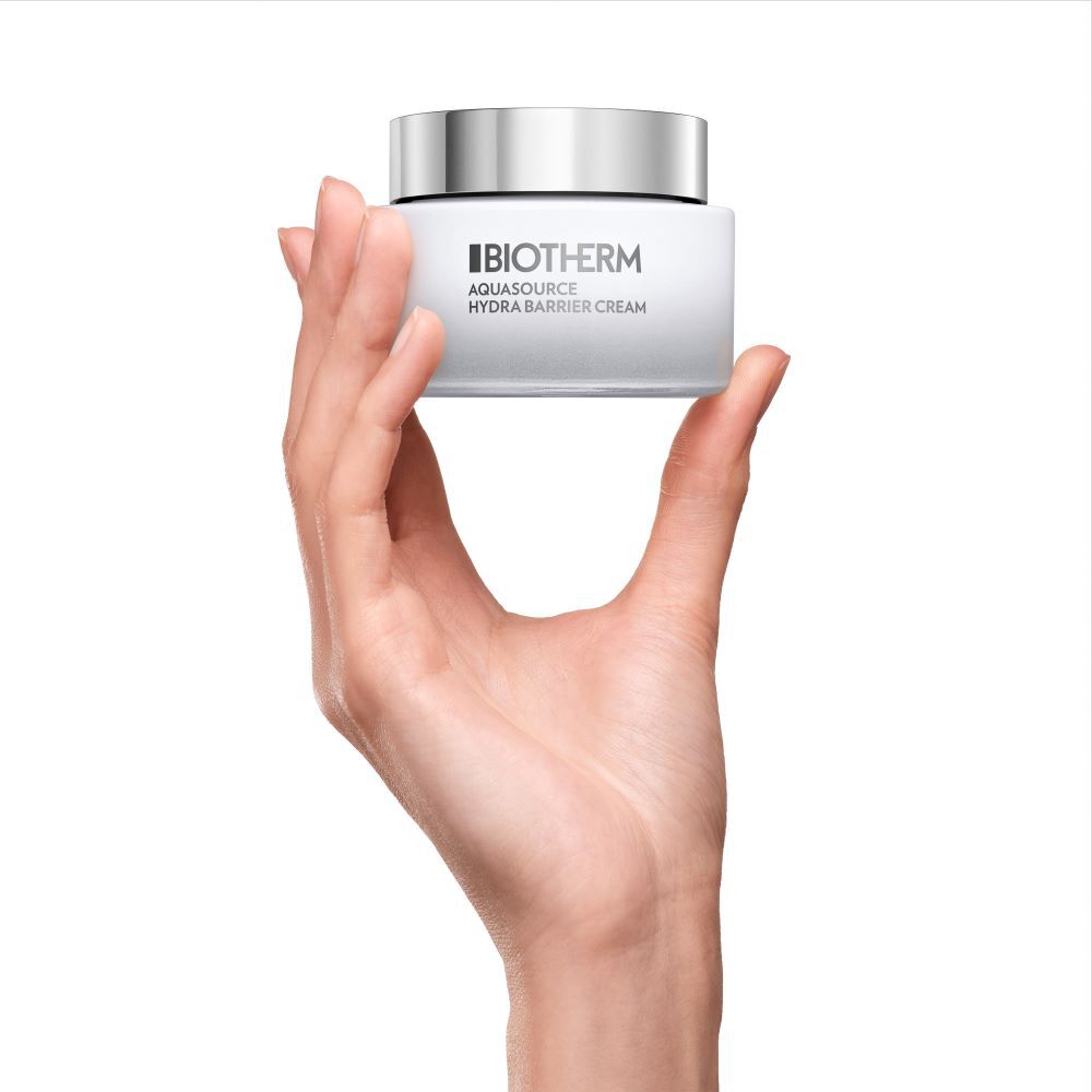 Eine Hand halt ein weißes Kosmetikglas aufrecht; der Hintergrund ist weiß.