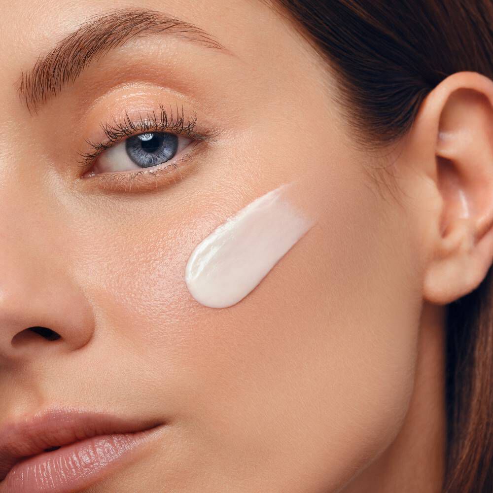 Gesicht mit Creme auf der Wange, Hautpflegeanwendung im Nahbereich.