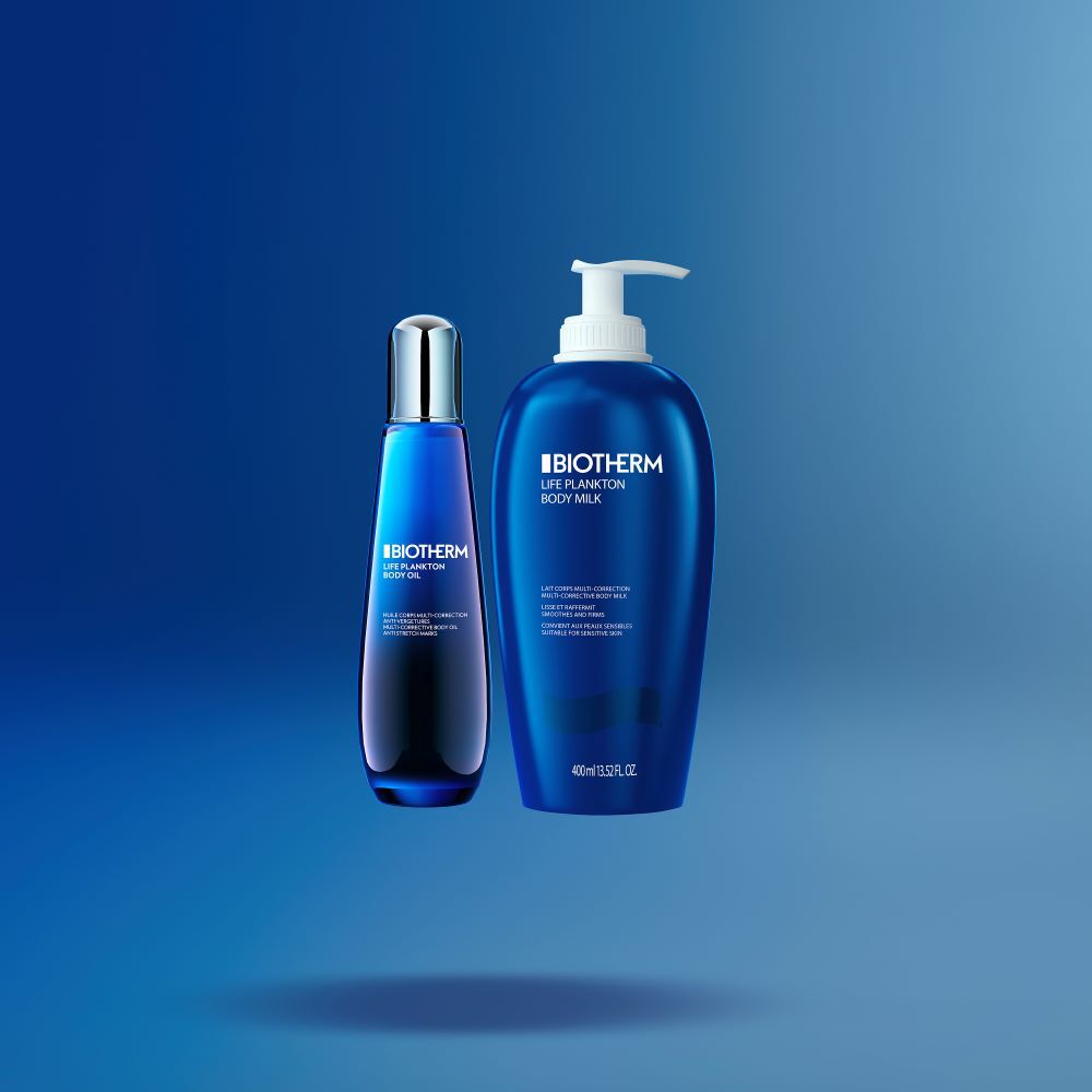 Zwei blaue Kosmetikflaschen stehen nebeneinander vor einem blauen Hintergrund.