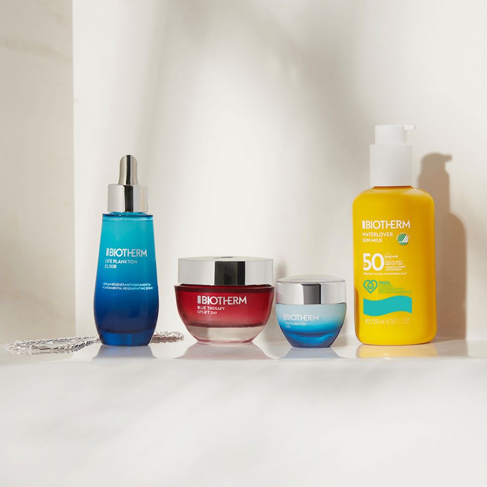 Mehrere Kosmetikflaschen stehen nebeneinander auf einem hellen Hintergrund.