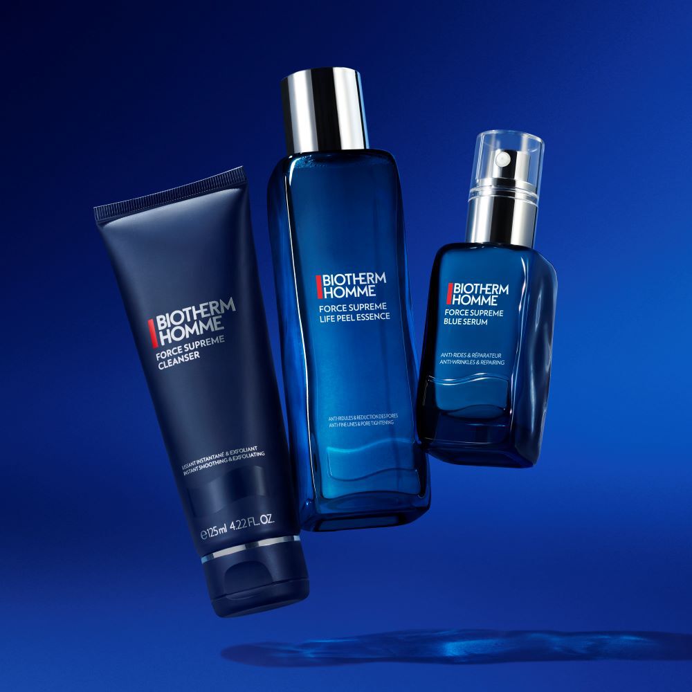 Drei blaue Kosmetikflaschen schweben vor blauem Hintergrund.